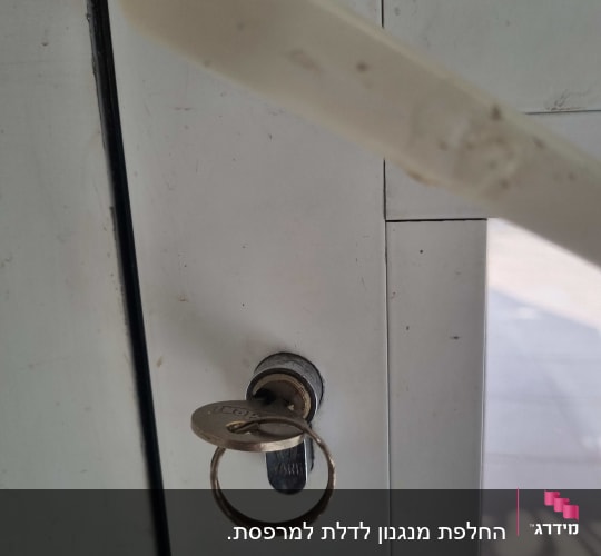 מנעול עם מפתח בדלת לבנה